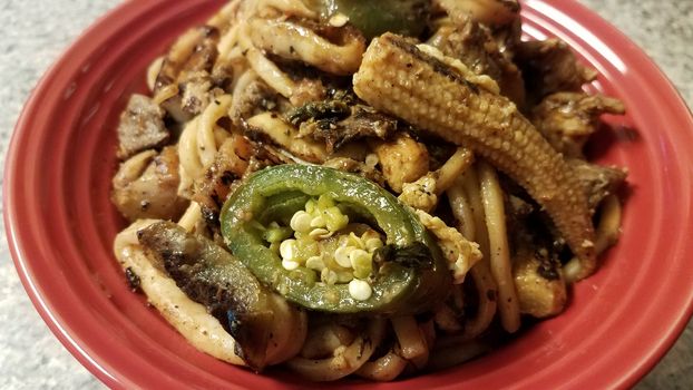 bowl with hot pepper noodles and corn and squid