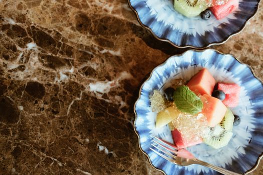 mixed fruit papaya kiwi blueberry watermelon orange in blue dish