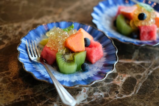 mixed fruit papaya kiwi blueberry watermelon orange in blue dish