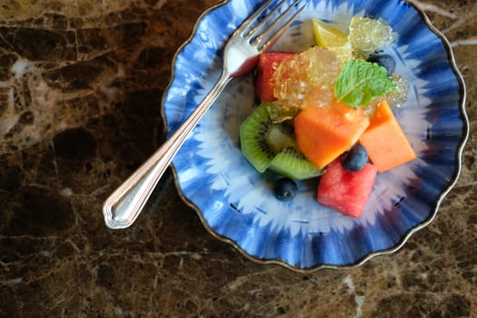 mixed fruit papaya kiwi blueberry watermelon orange in blue dish