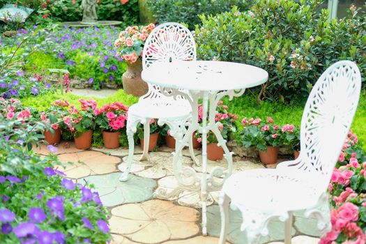 white metal seat chair in flower garden park in spring summer