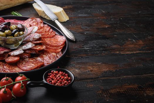 Spanish cold meat plate, chorizo, fuet, lomo,longaniza and salchichon on wooden table with copy space.