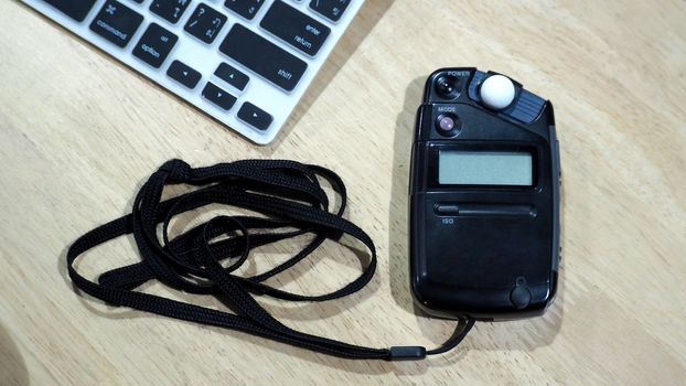 Light meter black color on the wood texture table and top view angle.