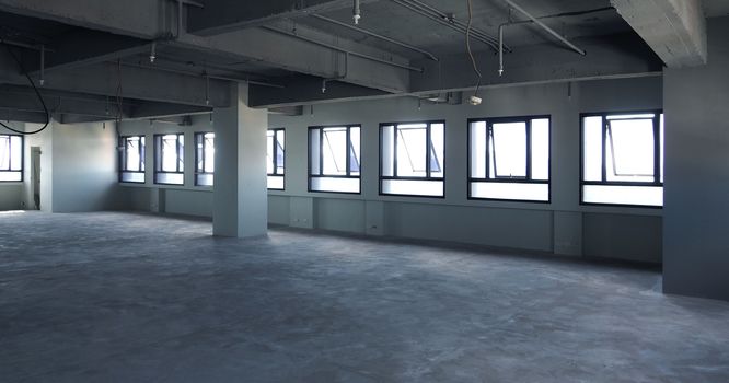 Abandoned office room that old and dirty floor and wall and have window around and indoor shot.