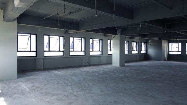 Abandoned office room that old and dirty floor and wall and have window around and indoor shot.