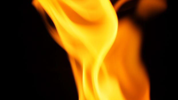 Blurred hot danger fire blazing and yellow color and black background.