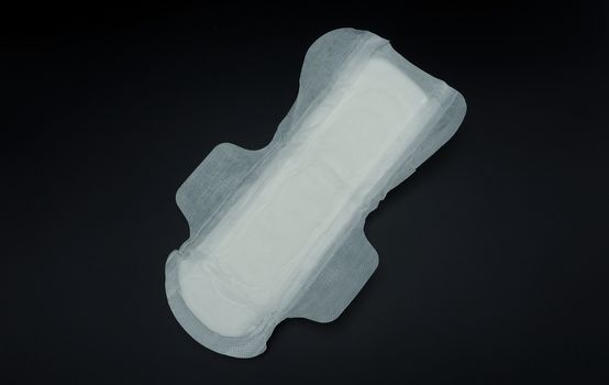 White clean hygiene sanitary napkin which soft and comfortable gently to skin on black background.