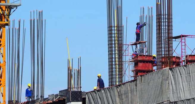 Labor working on construction site that have industry material on high building and have high risk in danger on thier life.