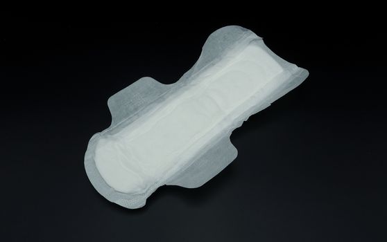 White clean hygiene sanitary napkin which soft and comfortable gently to skin on black background.