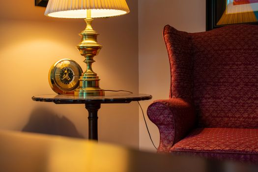 A Comfortable Red Chair, a Round Wooden Table, and a Lamp inside a Suburban Home