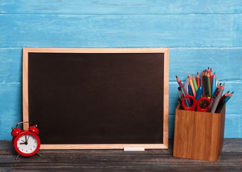 Mockup of Black board, pencils, cloak, chalks on wooden background