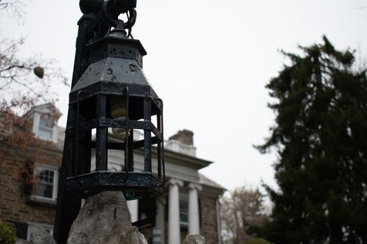 A Medieval Hanging Light in Front of a Cobblestone Mansion