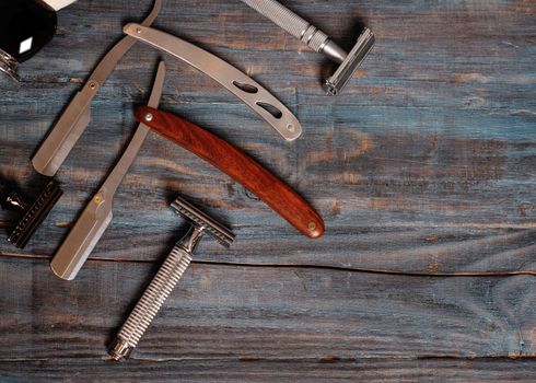 Razors and brush on wooden background.