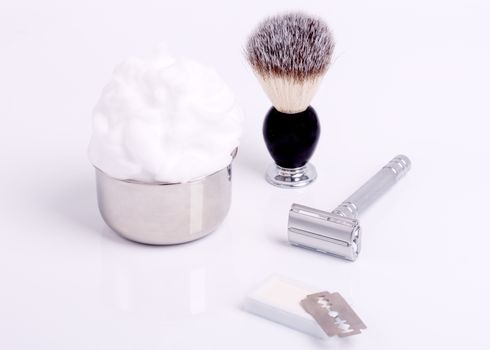 Razors, brush, foam and blade on a white background.