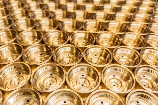 an abstract perspective industrial close-up background of shiny brass metal threaded hexagonal fitting parts.