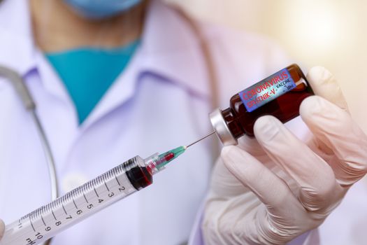 Covid-19, Coronavirus vaccine concept. Doctor, nurse, scientist, researcher hand in latex gloves holding vaccine in glass vial, Hands of doctor holding syringe and take vaccine from glass vial.