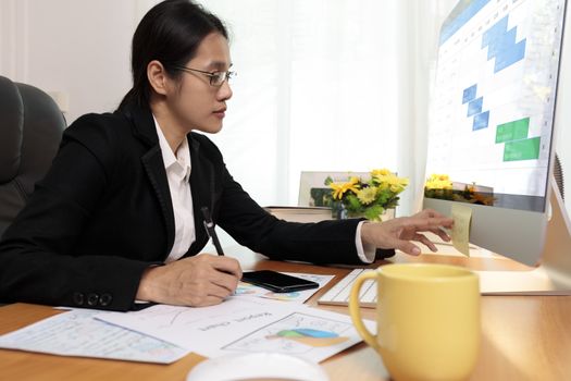 Business woman working in office looking and check paper note. business people analysis scheduler data on PC screen. Business people check calendar planner organisation.