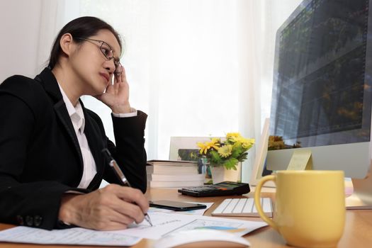 Business woman working in office with computer thinking analysis stock chart. business people working at home with PC screen. Business and finance ,work at home concept