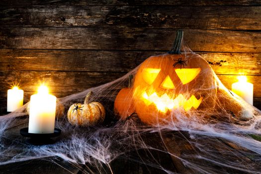 Jack O Lantern Halloween pumpkins, spiders on web and burning candles