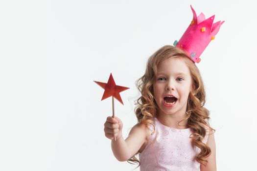 Beautiful little candy princess girl in crown holding star shaped magic wand isolated on white