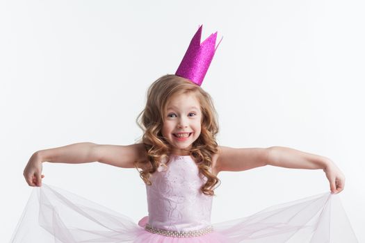 Little cute girl posing in pink halloween princess costume and crown isolated on white background