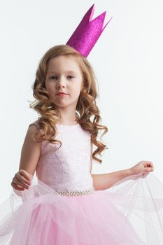 Little cute girl posing in pink halloween princess costume and crown isolated on white background