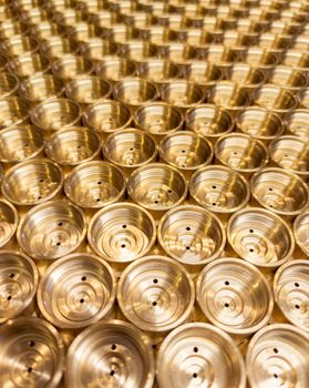 an abstract perspective industrial close-up background of shiny brass metal threaded hexagonal fitting parts.