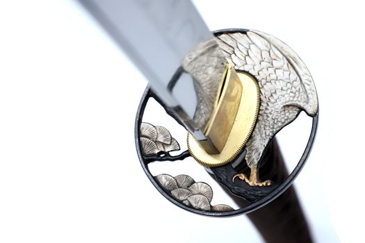 Tsuba is a hand guard of Japanese sword made of steel​ isolated in white background. Selective focus.