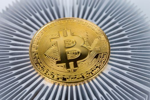Bitcoin shiner close-up on aluminium heatsink with selective focus.