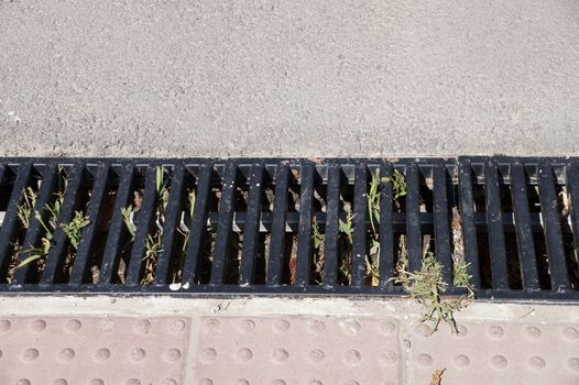 cast iron street drainage on the sidewalk