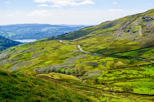 The Struggle road at Kirkstone Pass leading to Windermere lake Ambleside with Snarker Pike of Red Screes mountain on right in Lake District England