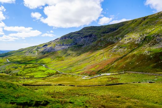 The Struggle road at Kirkstone Pass leading to Windermere lake Ambleside with Snarker Pike of Red Screes mountain on right in Lake District England