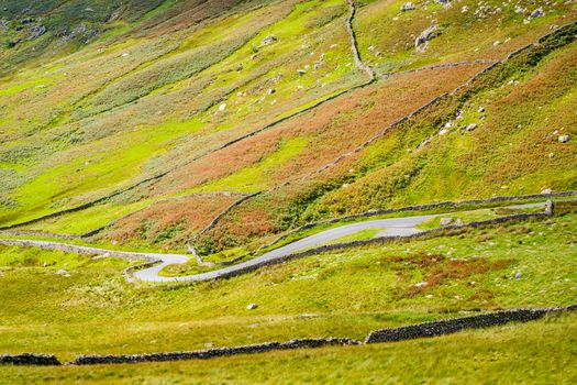 The Struggle road at Kirkstone Pass leading to Windermere lake Ambleside with Snarker Pike of Red Screes mountain on right in Lake District England