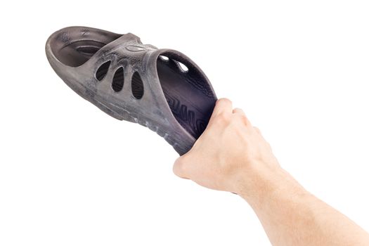 caucasian hand holding black rubber slipper like weapon against cockroach.