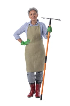 Gardening. Mature woman gardener worker with rake isolated on white background, full length portrait