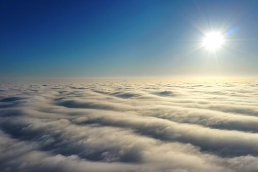 Aerial photography, rays of bright sunlight falling on dense gray clouds and reflected in blurred spots, a photograph about 500 meters high, taken by a drone of the latest generation from the height.