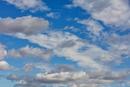 White and gray fluffy clouds float high in the backlight.