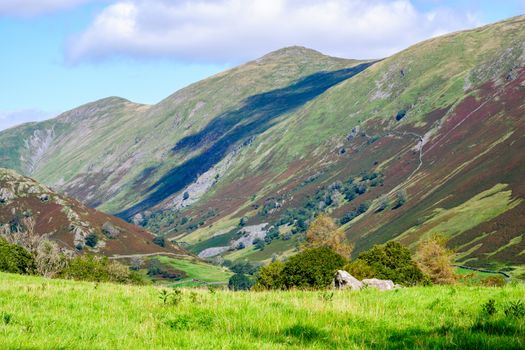 Rolling fells and valley in the Lake District UK with green fields in the summertime