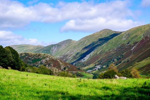 Rolling fells and valley in the Lake District UK with green fields in the summertime