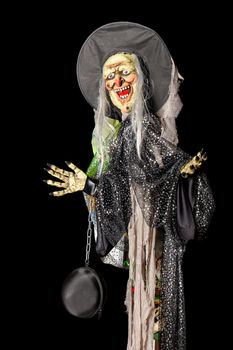 Halloween, death doll in a black hat, rags and a black bag on a metal chain on his arm.