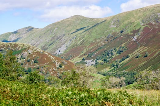 Rolling fells and valley in the Lake District UK with green fields in the summertime