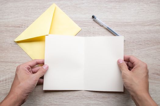 Male hands writing Empty cards on wooden table.