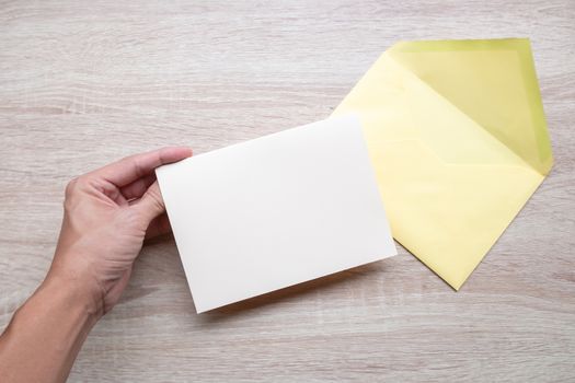 Male hands writing Empty cards on wooden table.