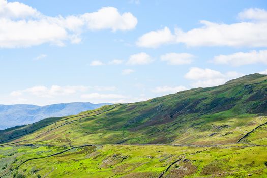 The Struggle road at Kirkstone Pass leading to Windermere lake Ambleside with Snarker Pike of Red Screes mountain on right in Lake District England