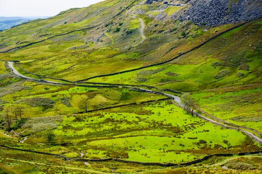 The Struggle road at Kirkstone Pass leading to Windermere lake Ambleside with Snarker Pike of Red Screes mountain on right in Lake District England