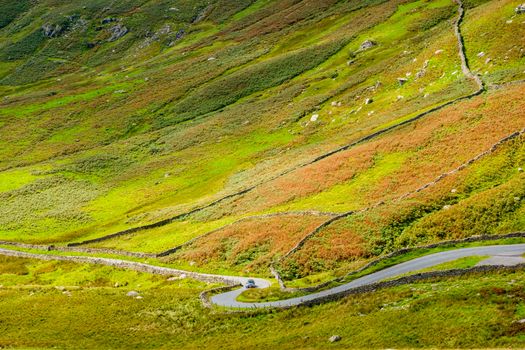 The Struggle road at Kirkstone Pass leading to Windermere lake Ambleside with Snarker Pike of Red Screes mountain on right in Lake District England
