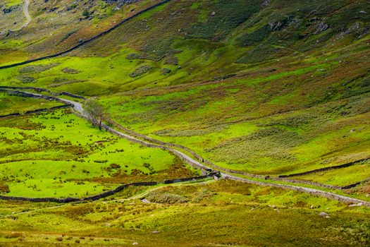 The Struggle road at Kirkstone Pass leading to Windermere lake Ambleside with Snarker Pike of Red Screes mountain on right in Lake District England