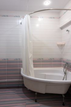 View of the acrylic bathtub in the bathroom interior