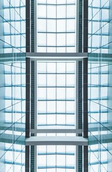 View through modern skylight of blue glass. Roof of building with square symmetric sections. Contemporary architectural style. Abstract backgrounds and backdrops.