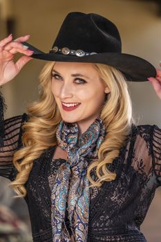 A gorgeous blonde model dressed as a cowgirl enjoying the outdoor weather
